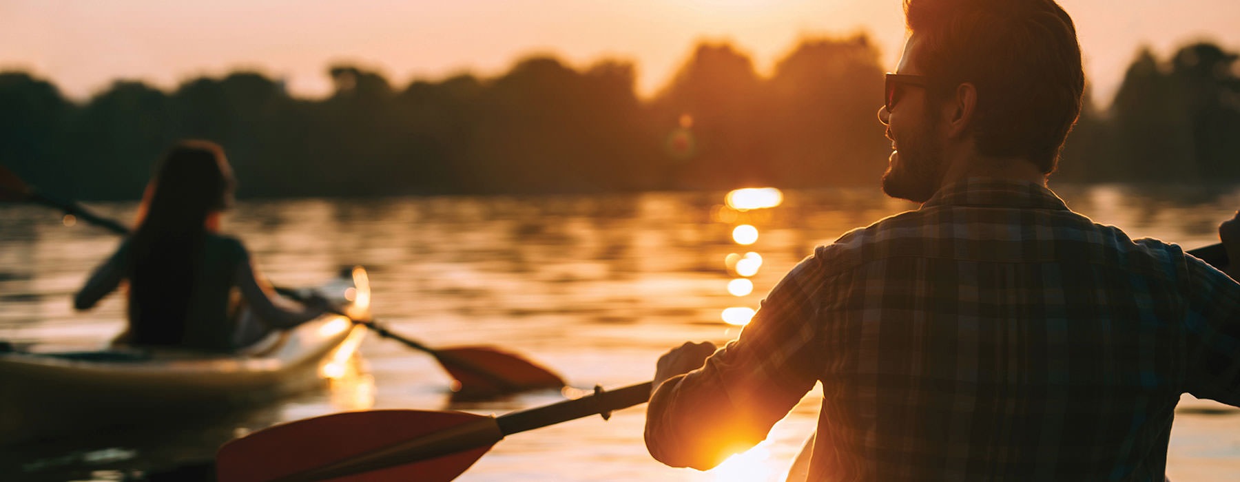 people kayaking on a lake during sunset
